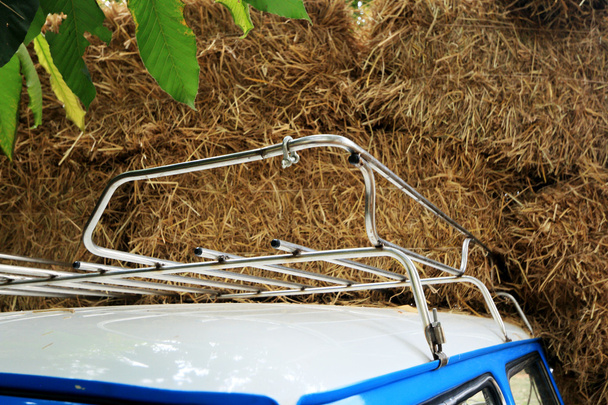 Part blue vintage car with a pile of straw. - Photo, Image