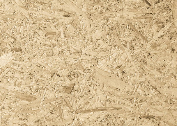 Panneau aggloméré, OSB Orienté panneau de brin particule pressée panneau de bois recyclé fond avec motif de fibre de bois granuleux toile de fond de couleur brun crème jaune naturel - Photo, image