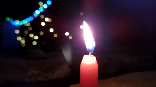 una fiamma di candela che dà luce in luce scura e sfondo lampeggiante alcune luci
 - Filmati, video