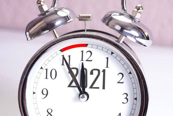 Un reloj despertador y Año Nuevo 2021
 - Foto, imagen
