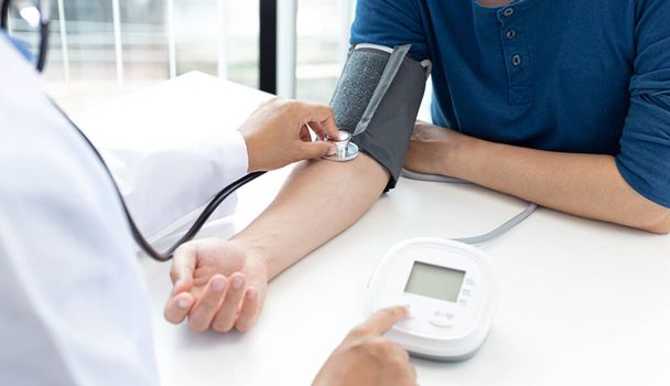 女性医師は血圧計と聴診器を使用して脈拍を測定します現代の病院の医療研究室で患者の病気を診断します。. - 写真・画像