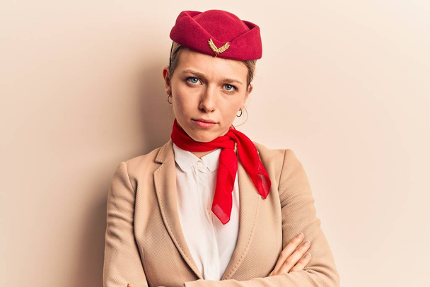 Young beautiful blonde girl wearing stewardess uniform skeptic and nervous, disapproving expression on face with crossed arms. negative person.  - Photo, Image