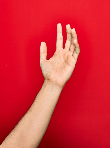 Hermosa mano de hombre mostrando cinco dedos levantados sobre fondo rojo aislado
 - Foto, Imagen
