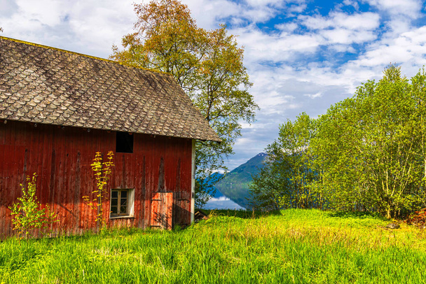 červený dřevěný dům v horách zelená tráva louka  - Fotografie, Obrázek