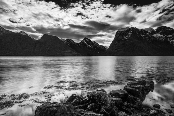 zwart-wit foto, wolken boven meer water in de natuur  - Foto, afbeelding
