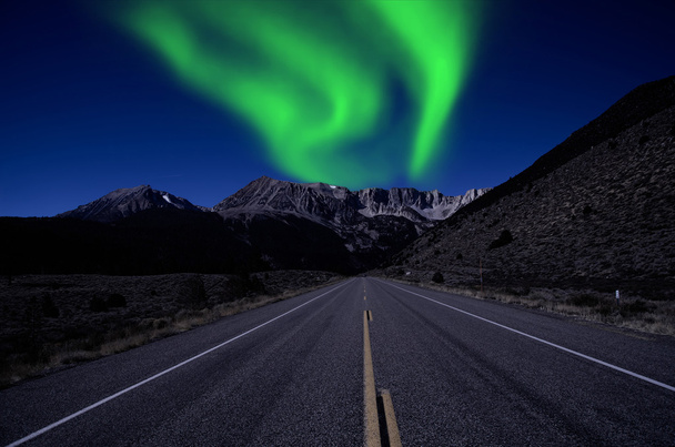 Northern lights over mountain highway - Фото, изображение