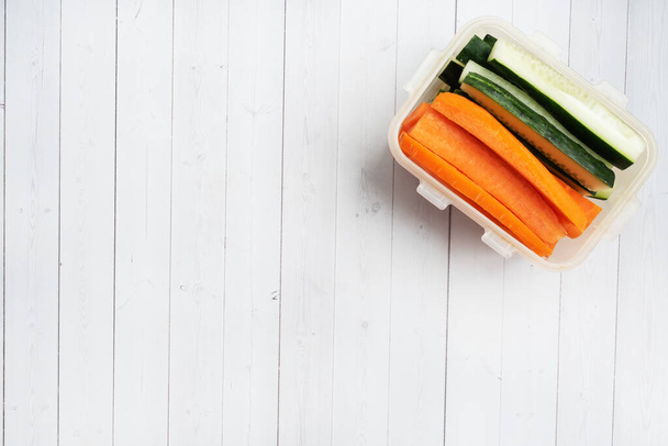 Bastoncini di carota e cetriolo freschi in un contenitore. Misurazione del volume in centimetri. Concetto di nutrizione alimentare. Copia spazio
 - Foto, immagini
