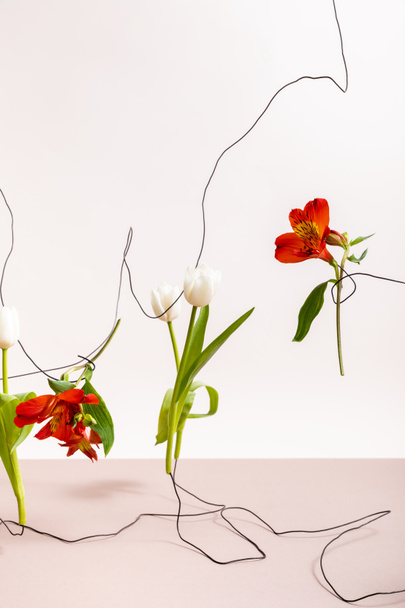 floral composition with tulips and red Alstroemeria on wires isolated on white - Foto, Bild