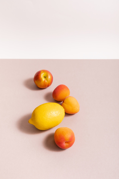 fruit composition with lemon and apricots on beige surface isolated on white - 写真・画像