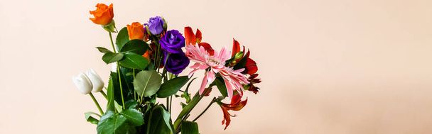 floral composition with bouquet of colorful flowers on beige background, panoramic crop - Fotó, kép