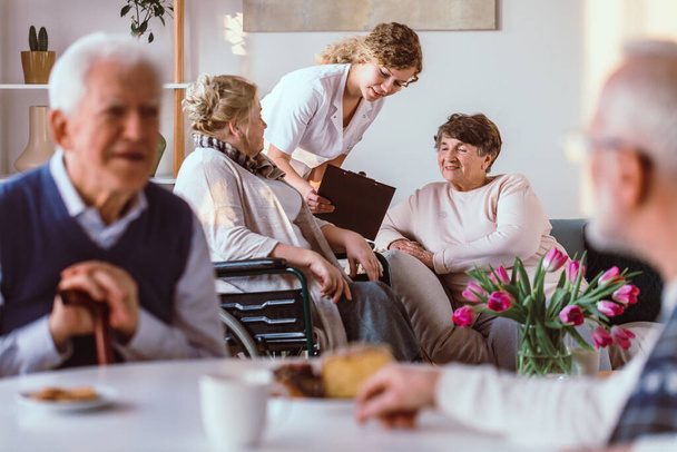Personas mayores pasando tiempo con amigos en la sala de estar en un hogar de ancianos
 - Foto, imagen