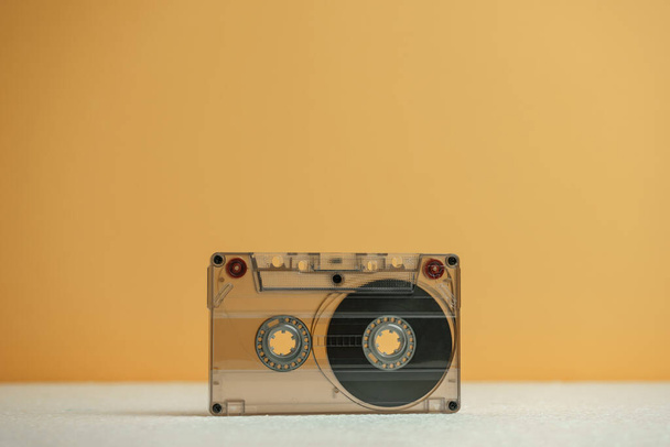 Close up Audio-Kassette Band auf einem weißen Tisch und gelben Raum. Minimalismus Retro-Stil-Konzept. 80er Jahre. Hintergrundmuster für Design. - Foto, Bild