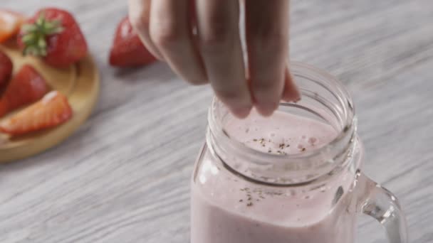 Organic milky strawberry smoothie in a glass. Healthy dessert - Felvétel, videó