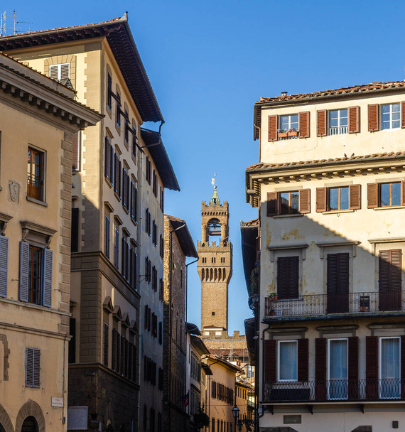 Beautiful old Palazzo Vecchio tower by Arnolfo di Cambio view from Santa Croce square among ancient buildings in Florence Tuscany Italy - Photo, Image