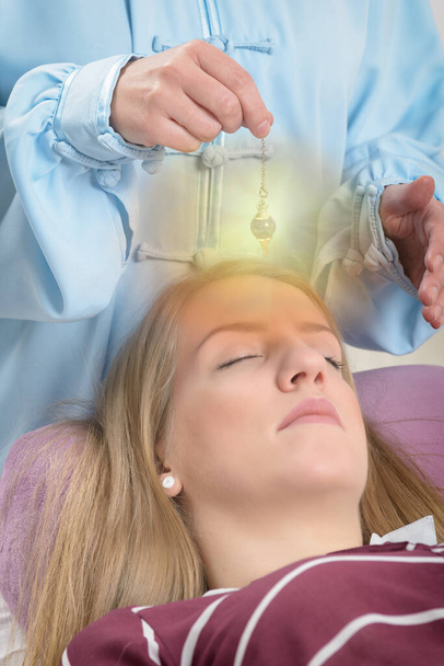 Terapeuta de medicina alternativa usando pêndulo para fazer um diagnóstico - Foto, Imagem