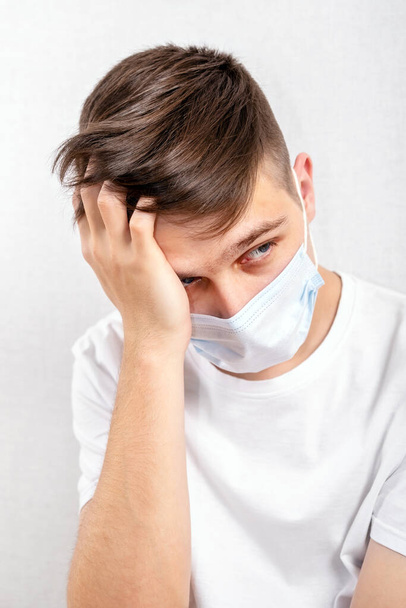 Portrait of Young Man in a Flu Mask by the Wall in the Room - Foto, Imagen