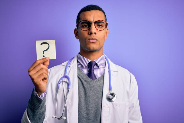 Schöner afrikanischer amerikanischer Arzt trägt Stethoskop mit Fragezeichen-Erinnerung und selbstbewusstem Gesichtsausdruck - Foto, Bild