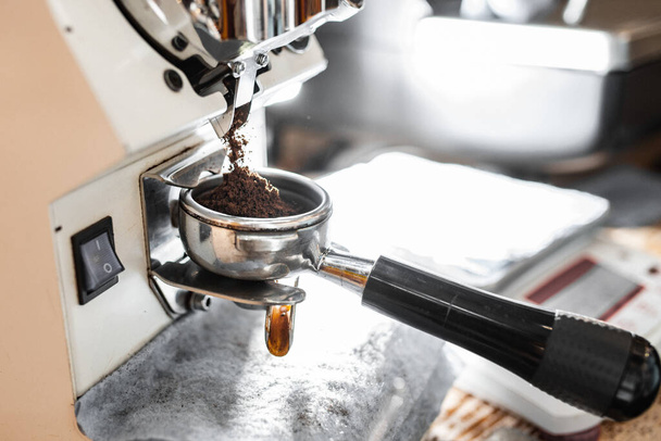 Vaření kávy v profesionálním kávovaru. detail držáku filtru s mletou kávou - Fotografie, Obrázek