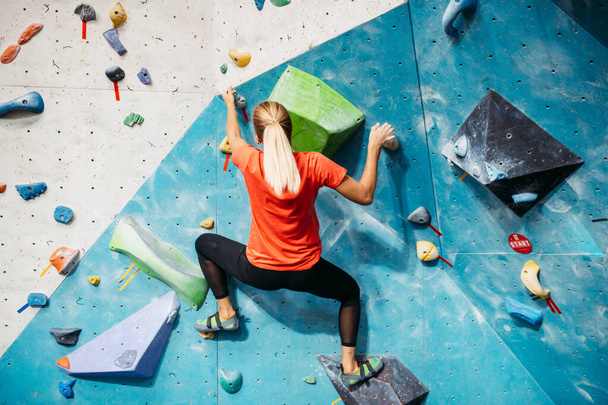 Pared de escalada de entrenamiento interior. Chica en un muro de escalada. Primer plano
 - Foto, imagen