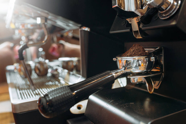 Hacer café en una máquina de café profesional. primer plano de un soporte de filtro con café molido
 - Foto, Imagen