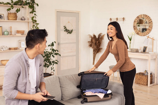 Joyful Travelers Couple Packing Suitcase For Vacation At Home - Foto, imagen