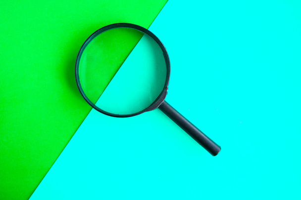 Magnifying glass on geometric green background. Minimal concept - Photo, image