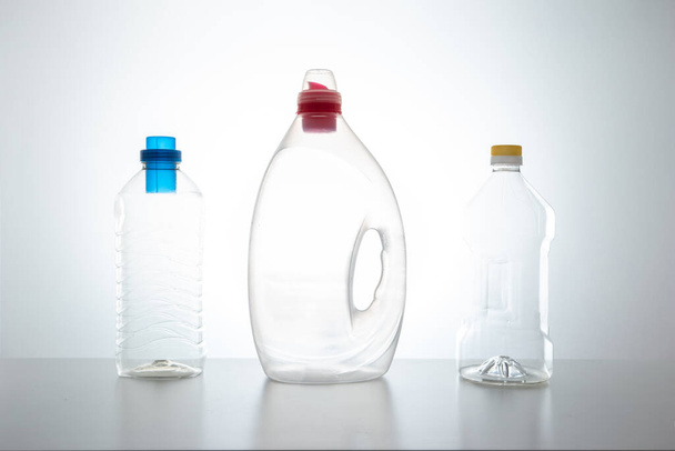Three large empty clear plastic bottles with no labels and different color caps studio shot isolated on white 2020 - Valokuva, kuva