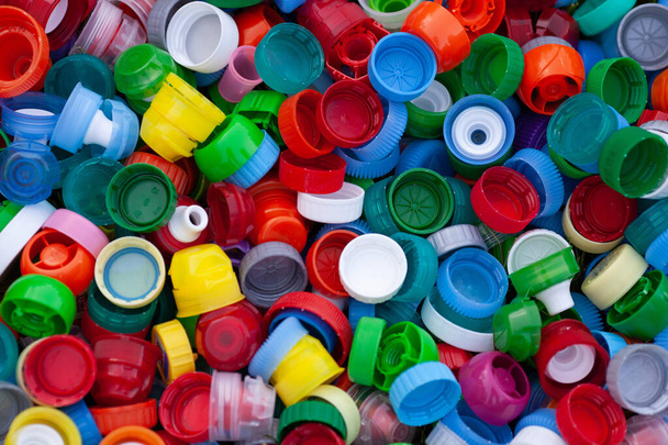 Se recogieron diferentes tipos de tapas de botellas para el reciclaje. Materias primas. Clasificación de basura. Fondo de color. Ecología y contaminación del planeta Tierra
.  - Foto, imagen