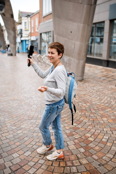 Dziewczyna trzyma selfie kij, robienie zdjęć i spacery po mieście - Zdjęcie, obraz