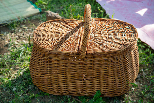 芝生の上で夏のピクニックのためのわらバスケット. - 写真・画像