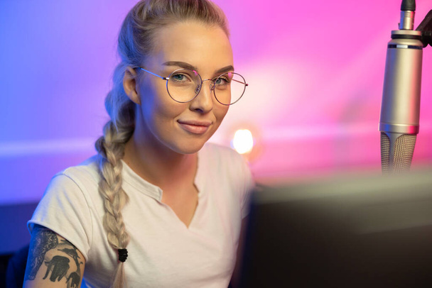 Portrait of Blonde Gamer Girl with Glasses Playing Online Video Game on Her Computer - Fotó, kép
