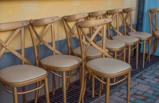 Wooden chairs gold color with soft seats. - Foto, afbeelding