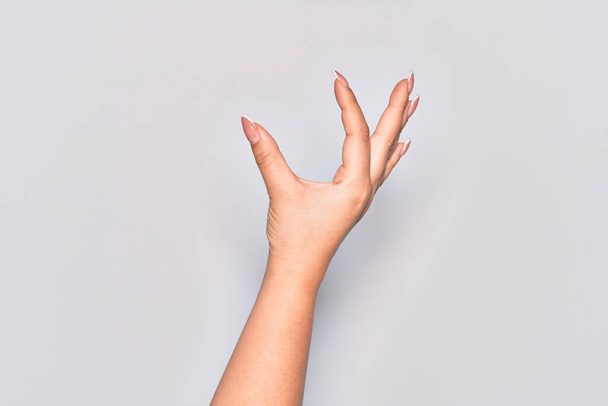 Рука кавказской молодой женщины собирает и берет невидимую вещь, держит предмет пальцами показывая пространство - Фото, изображение