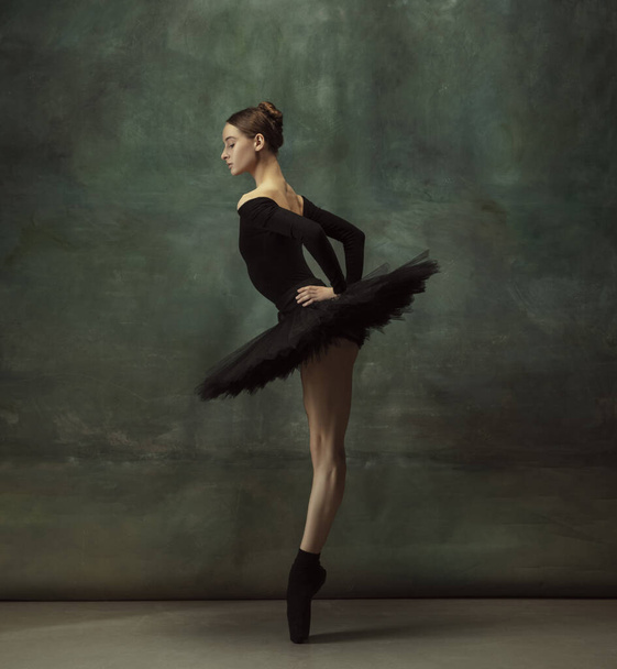 Young graceful tender ballerina on dark studio background - Фото, изображение