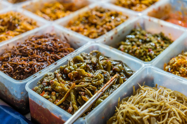 Буфет пластикових ящиків з гострими додатками до їжі, замовленого на вулиці в китайському ресторані. - Фото, зображення