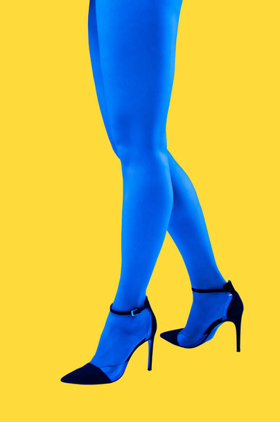 Close-up picture of womans beautiful blue legs in high heels shoes on acid yellow color background. Disco lights. Fasion. Surreal art. Funny modern art collage. Pop art. Zine culture. Side view. - Fotografie, Obrázek