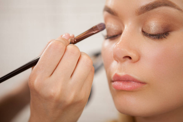 Cropped shot of a charming woman having professional makeup done at beauty studio - Photo, Image