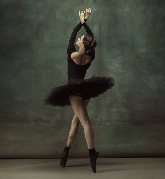 Молодая изящная нежная балерина на темном фоне студии
 - Фото, изображение