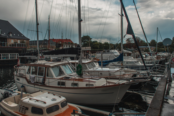 Bateaux dans le port avec ciel nuageux en arrière-plan à Copenhague, Danemark  - Photo, image