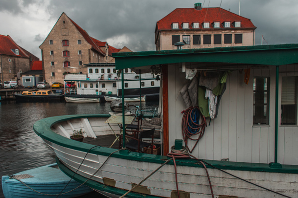 Barcos atracados en puerto con edificios y cielo nublado al fondo en Copenhague, Dinamarca
  - Foto, imagen
