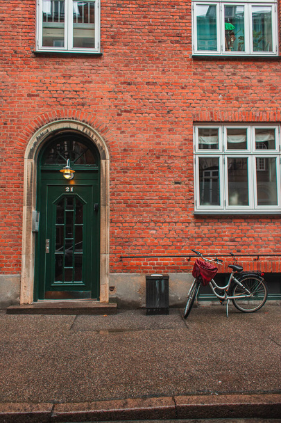Bicycle near brick facade of building on urban street in Copenhagen, Denmark  - Foto, afbeelding