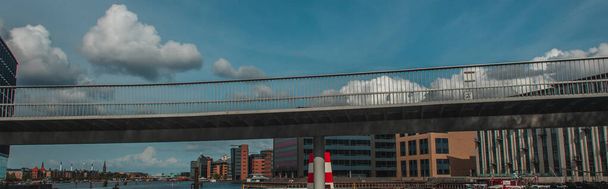 Panoramic shot of bridge with buildings and cloudy sky at background in Copenhagen, Denmark  - Photo, Image