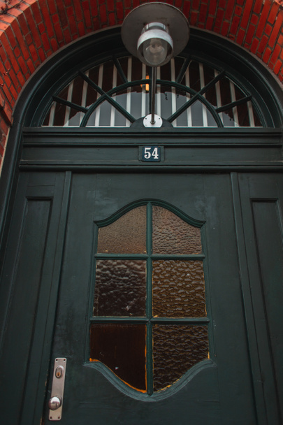 Vista de ángulo bajo de la linterna sobre la puerta negra en la fachada de ladrillo de la casa, Copenhague, Dinamarca
  - Foto, Imagen