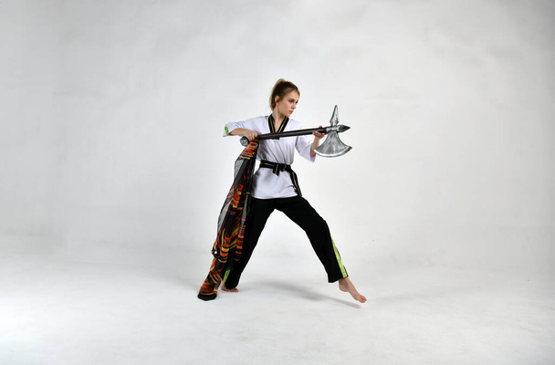 beautiful girl in a white and black suit attacks with military weapons - 写真・画像
