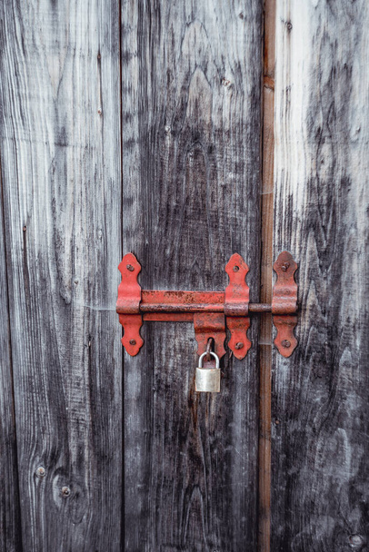 antique wooden gray door with a metal red lock 1 - Zdjęcie, obraz