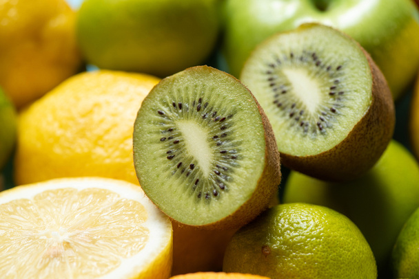 close up view of kiwi halves on lemons and limes - Foto, imagen