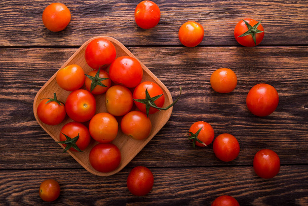 verse rode tomaat op een bord. houten tafel - Foto, afbeelding