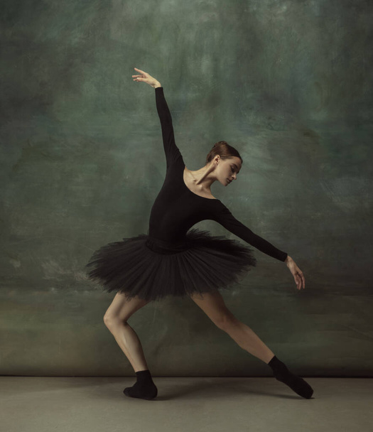 Young graceful tender ballerina on dark studio background - Fotoğraf, Görsel