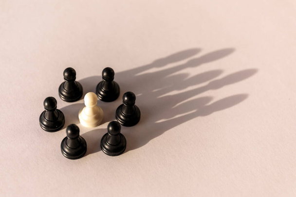 Plastový šachový kruh pěšců se stínem ve tvaru koruny na bílém pozadí. Týmová práce, skupinová dohoda a koncepce úspěchu - Fotografie, Obrázek