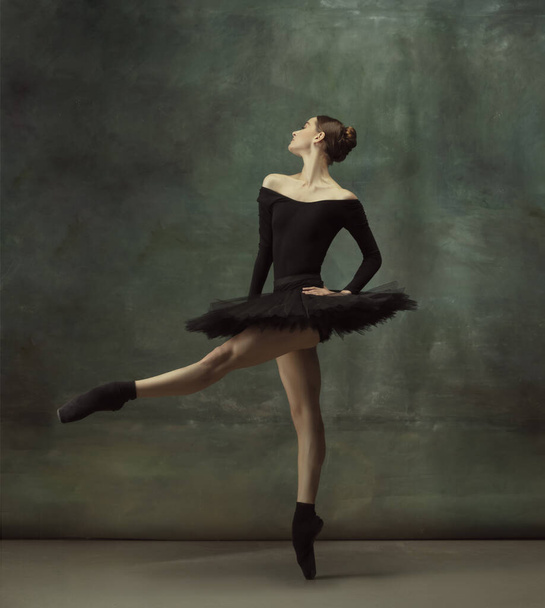 Young graceful tender ballerina on dark studio background - Photo, image